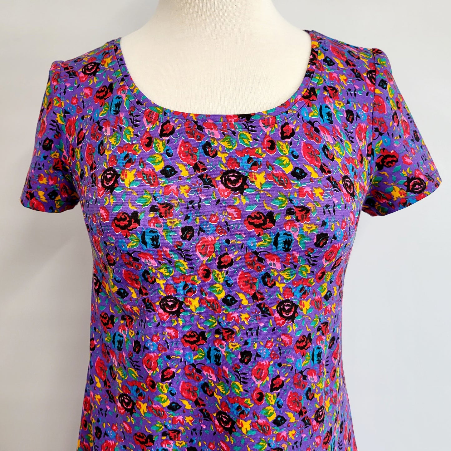 “Christine” dress in cotton jersey, small colorful flowers on a mauve background.