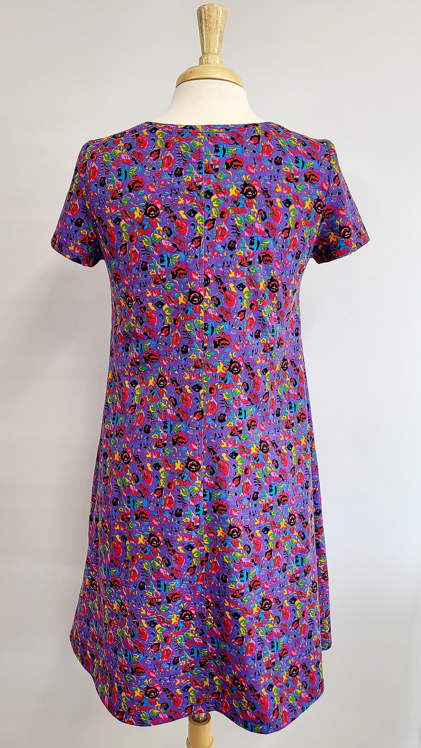 “Christine” dress in cotton jersey, small colorful flowers on a mauve background.