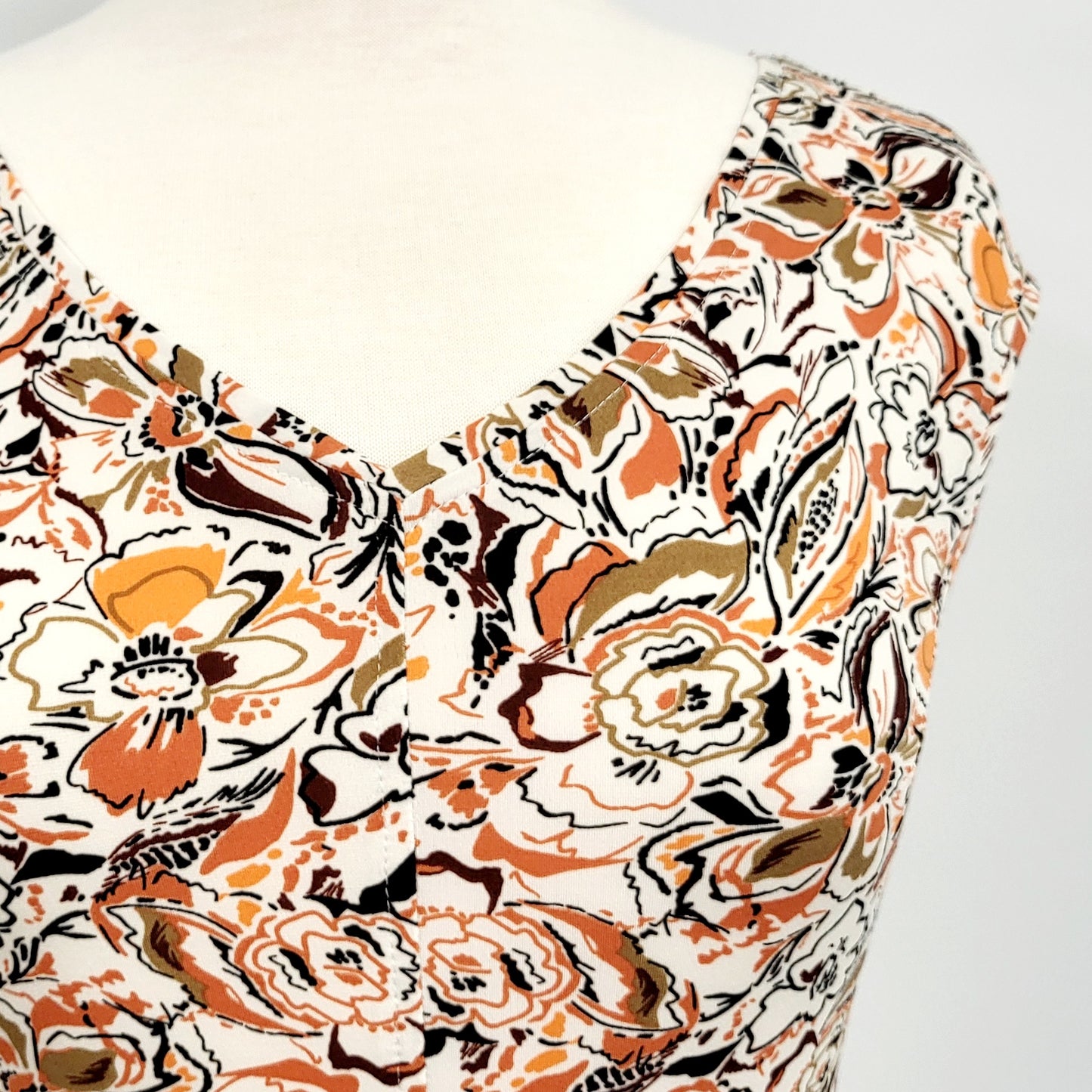 "Alice" dress printed in warm colors on a white background
