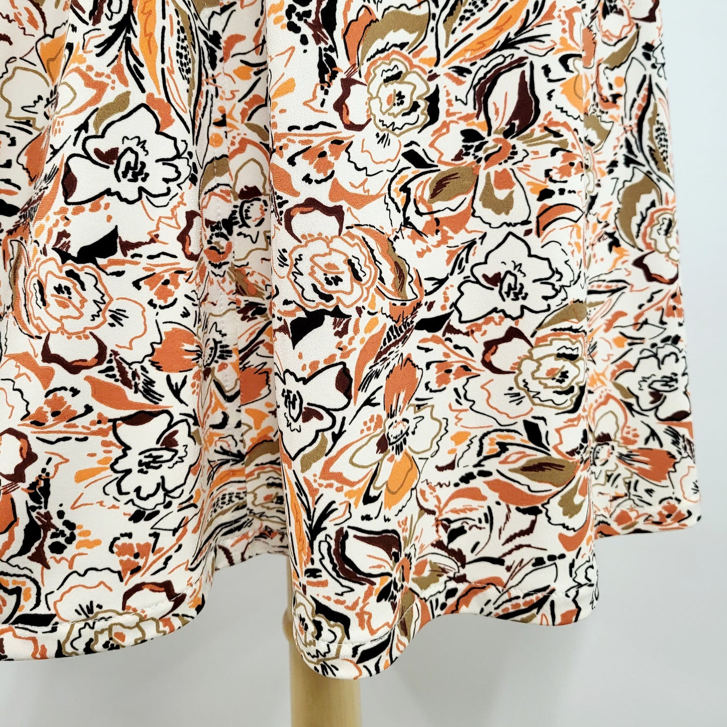 "Alice" dress printed in warm colors on a white background
