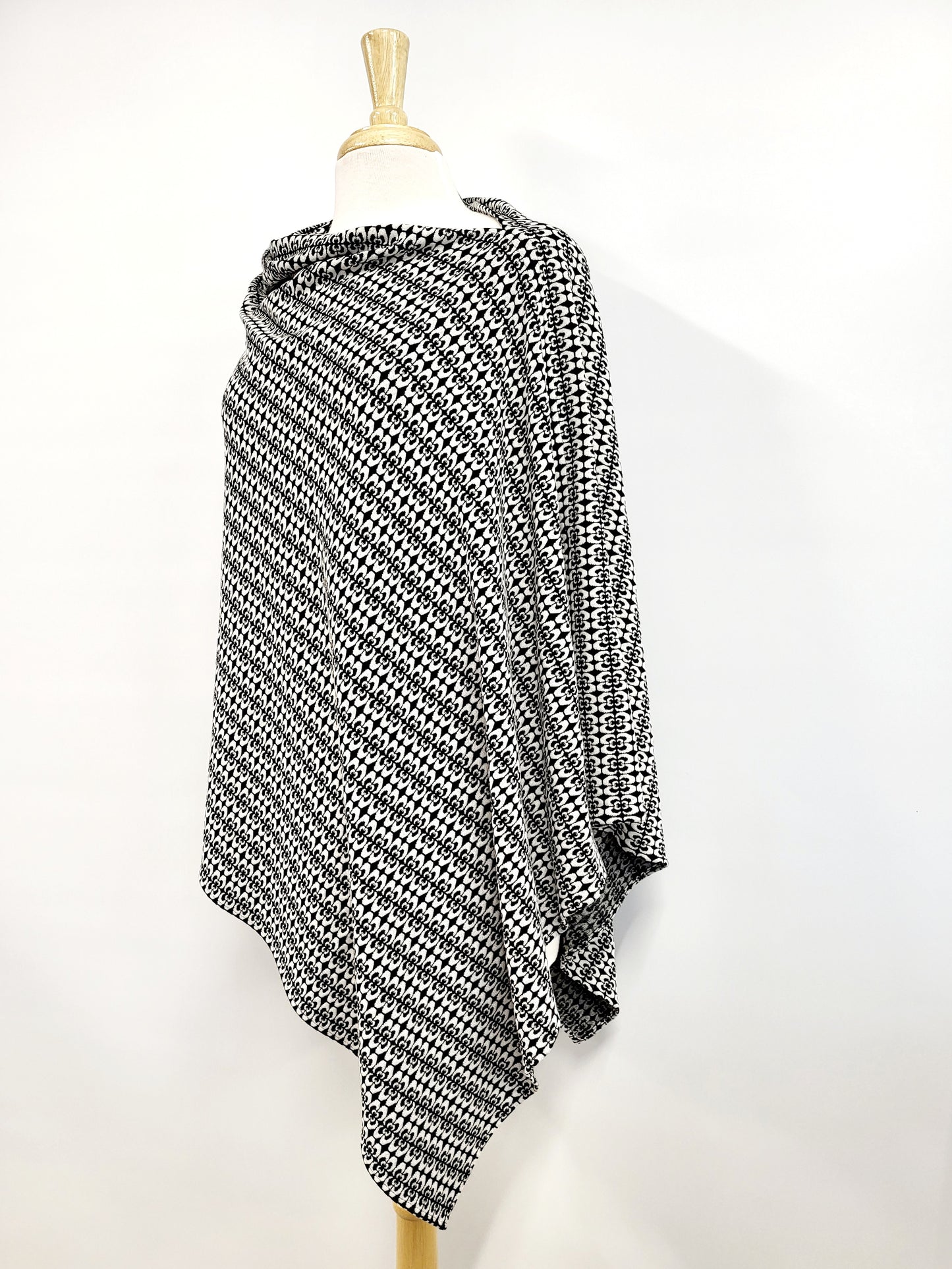 Long knitted poncho with white and black pattern.