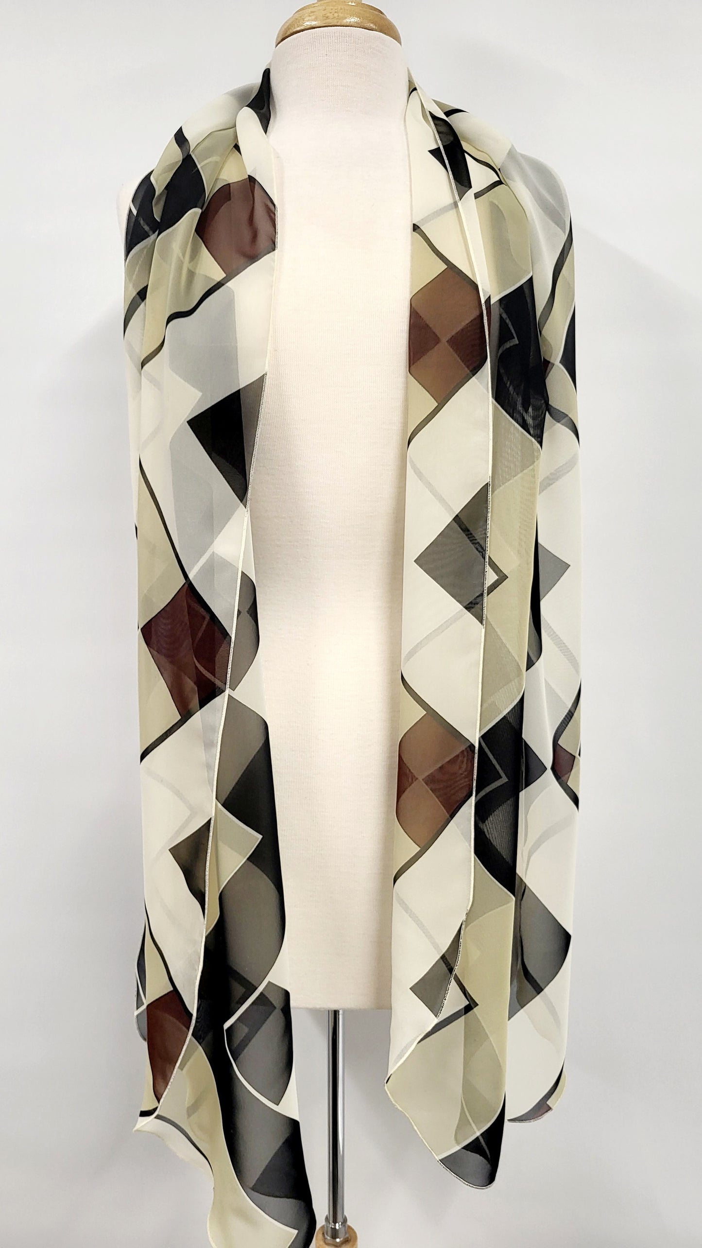 Long, lightweight scarf with geometric patterns in earth tones and black