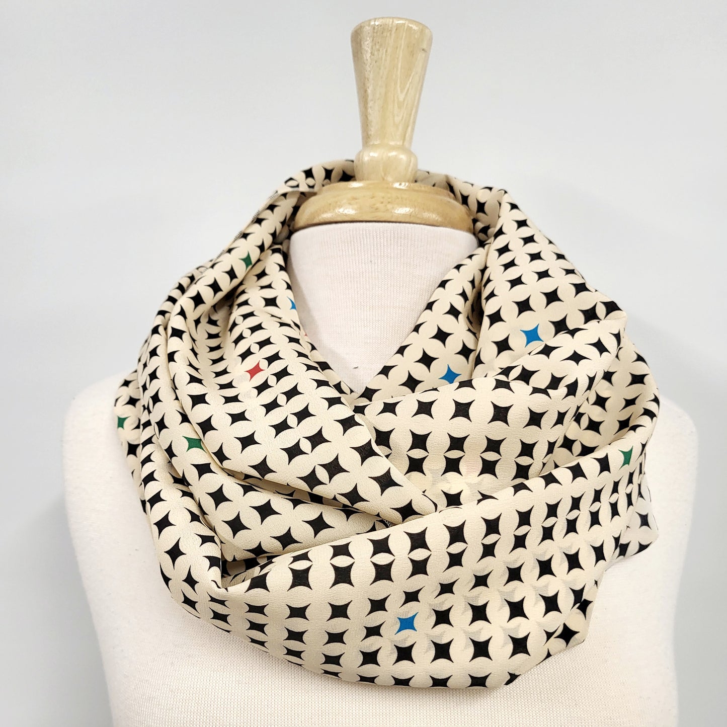 Circular silk scarf, cream and black with small touches of color.