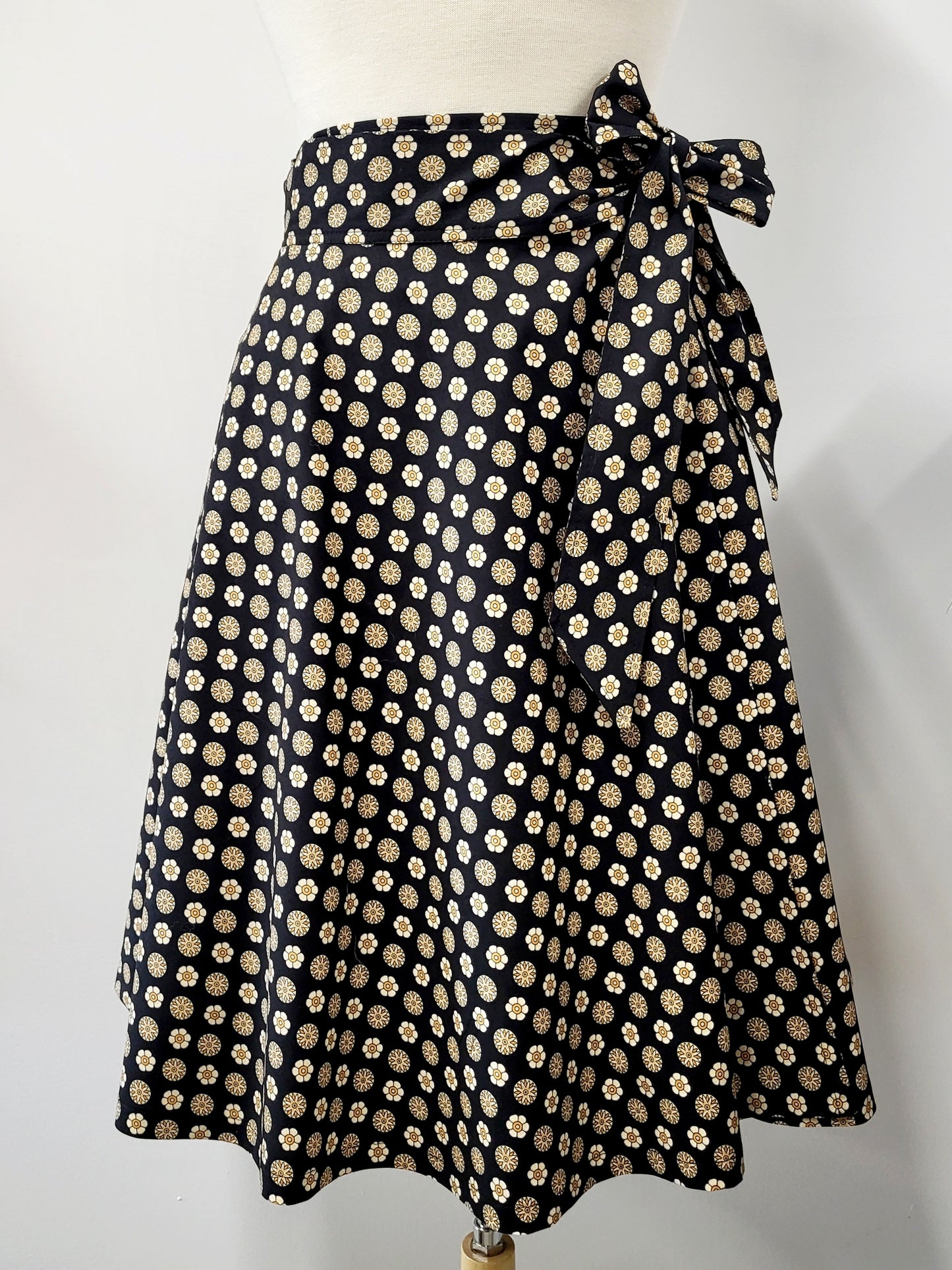 Cotton wrap skirt with small beige and yellow patterns on a black background
