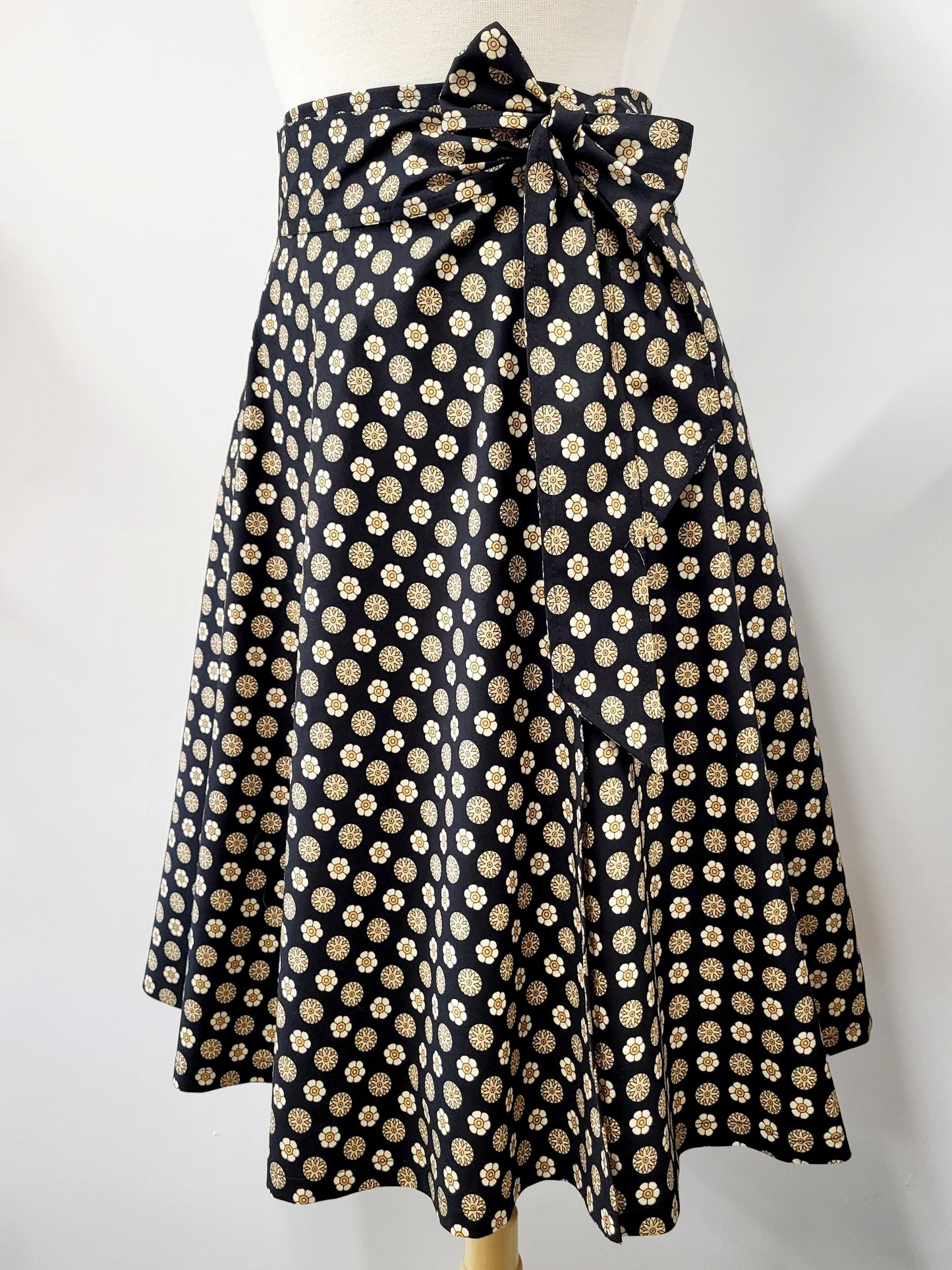 Cotton wrap skirt with small beige and yellow patterns on a black background