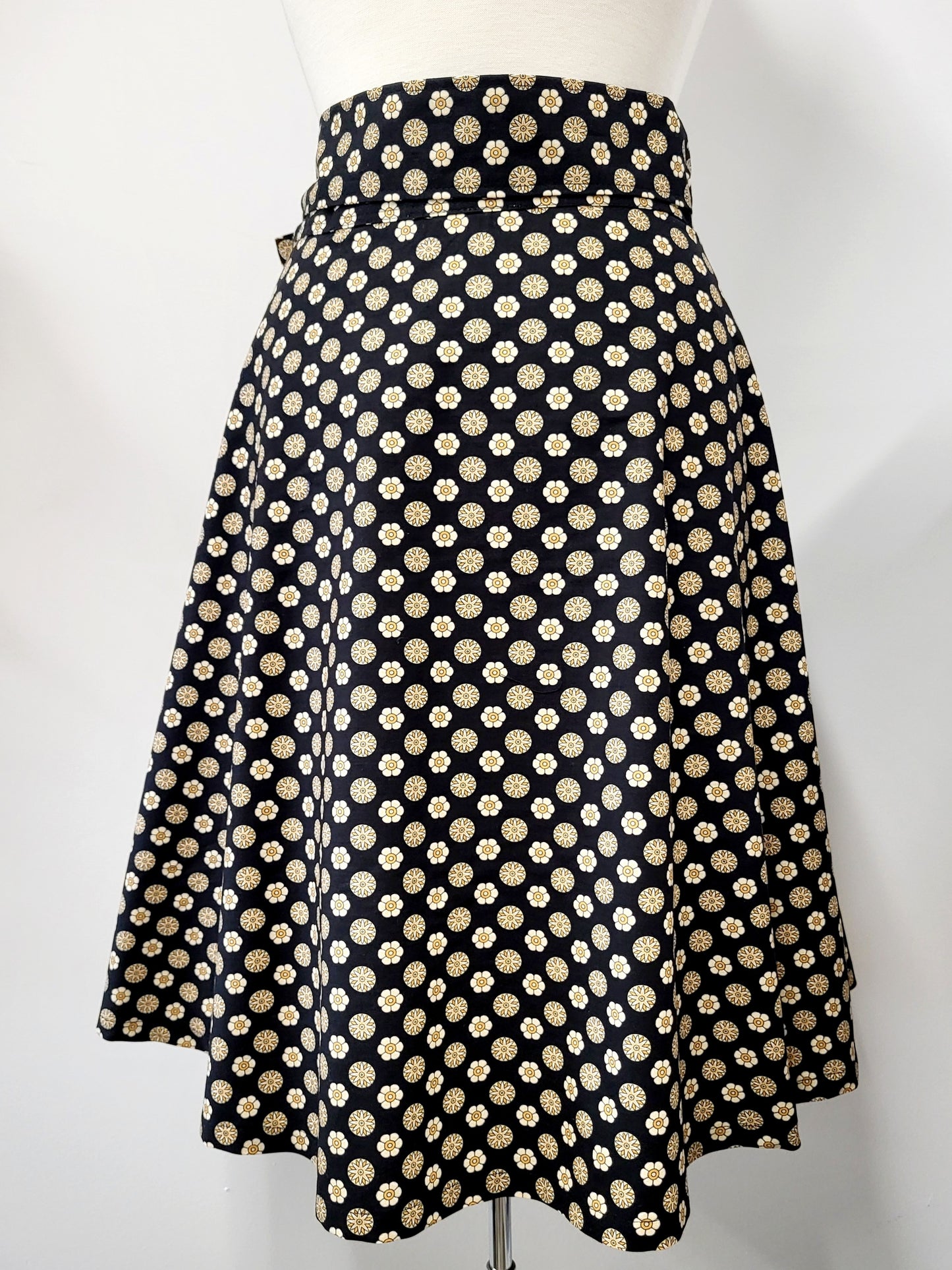 Cotton wrap skirt with small beige and yellow patterns on a black background