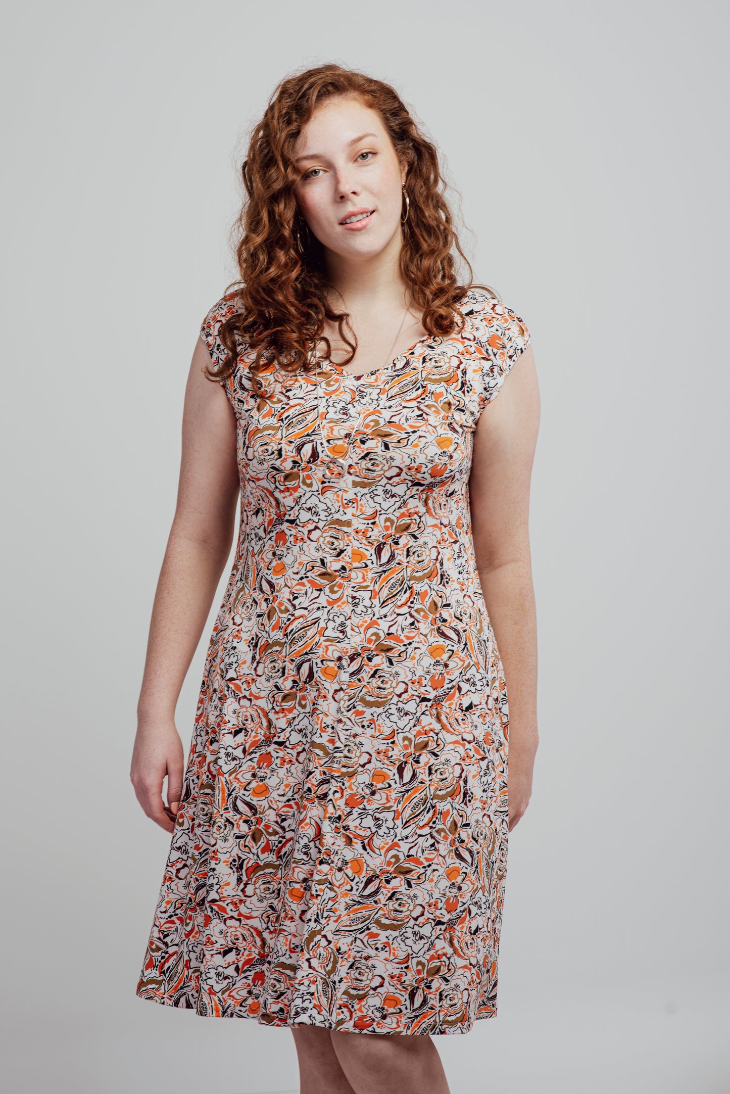 "Alice" dress printed in warm colors on a white background