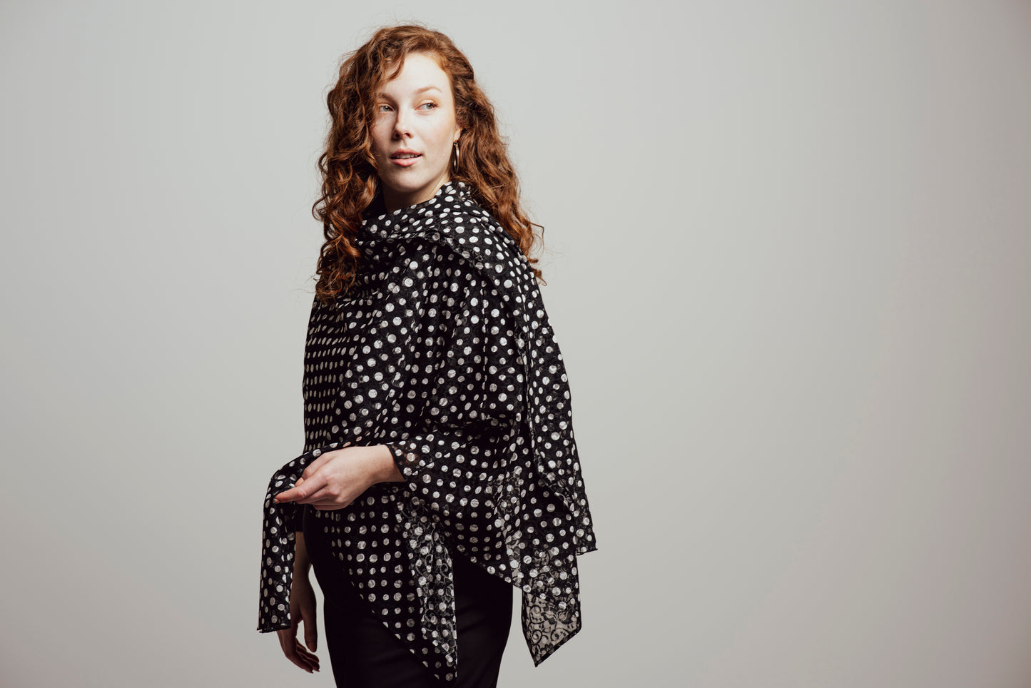 Short poncho in black lace with white polka dots.