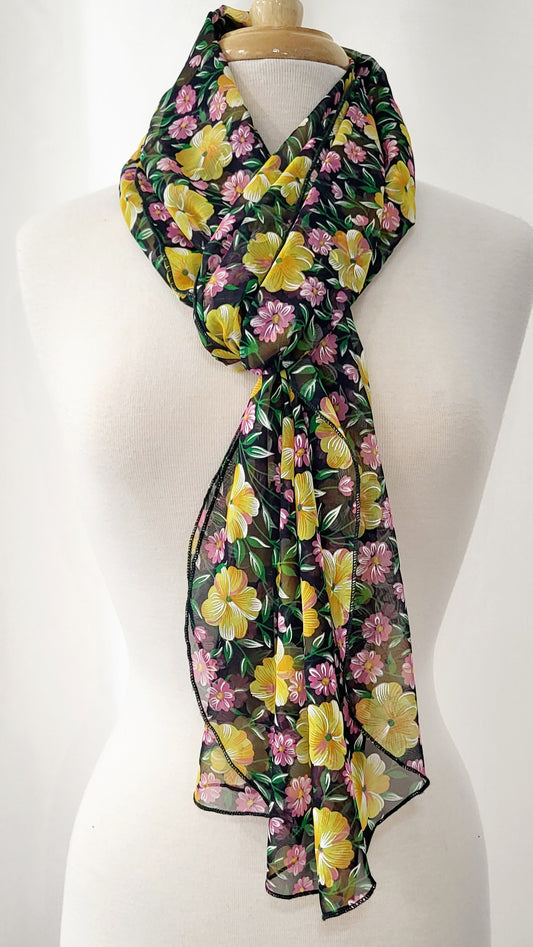 Foulard long en voilage imprimé de fleurs jaunes, roses et feuillage vert.