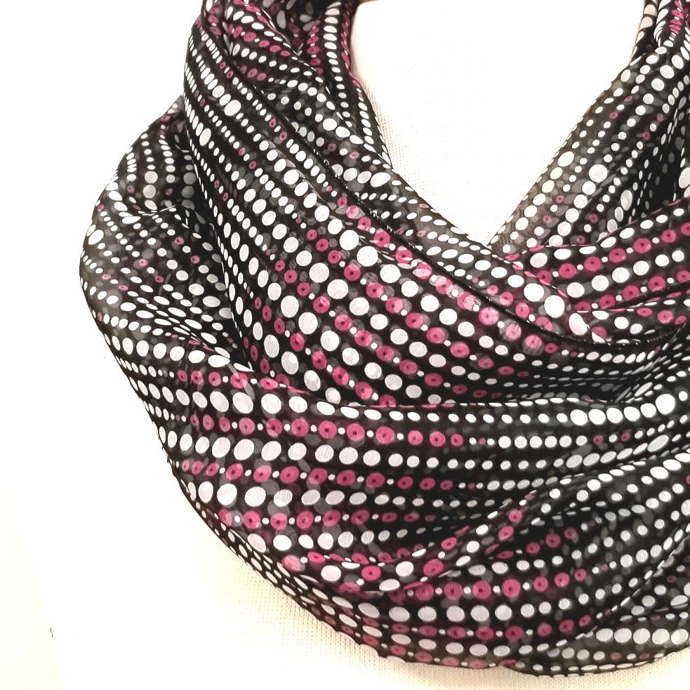 Circular scarf with small purple and white polka dots on a black background.