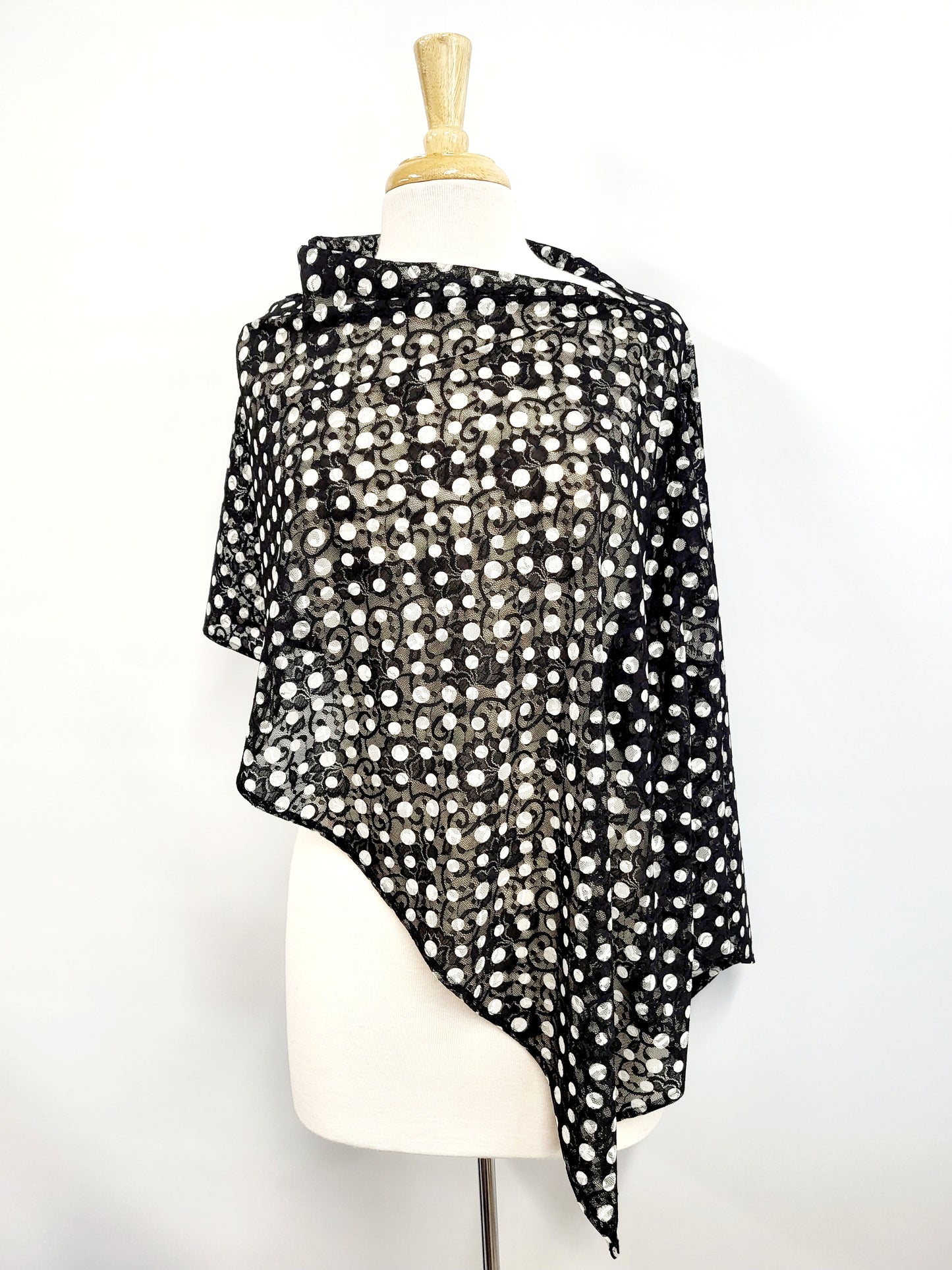 Short poncho in black lace with white polka dots.