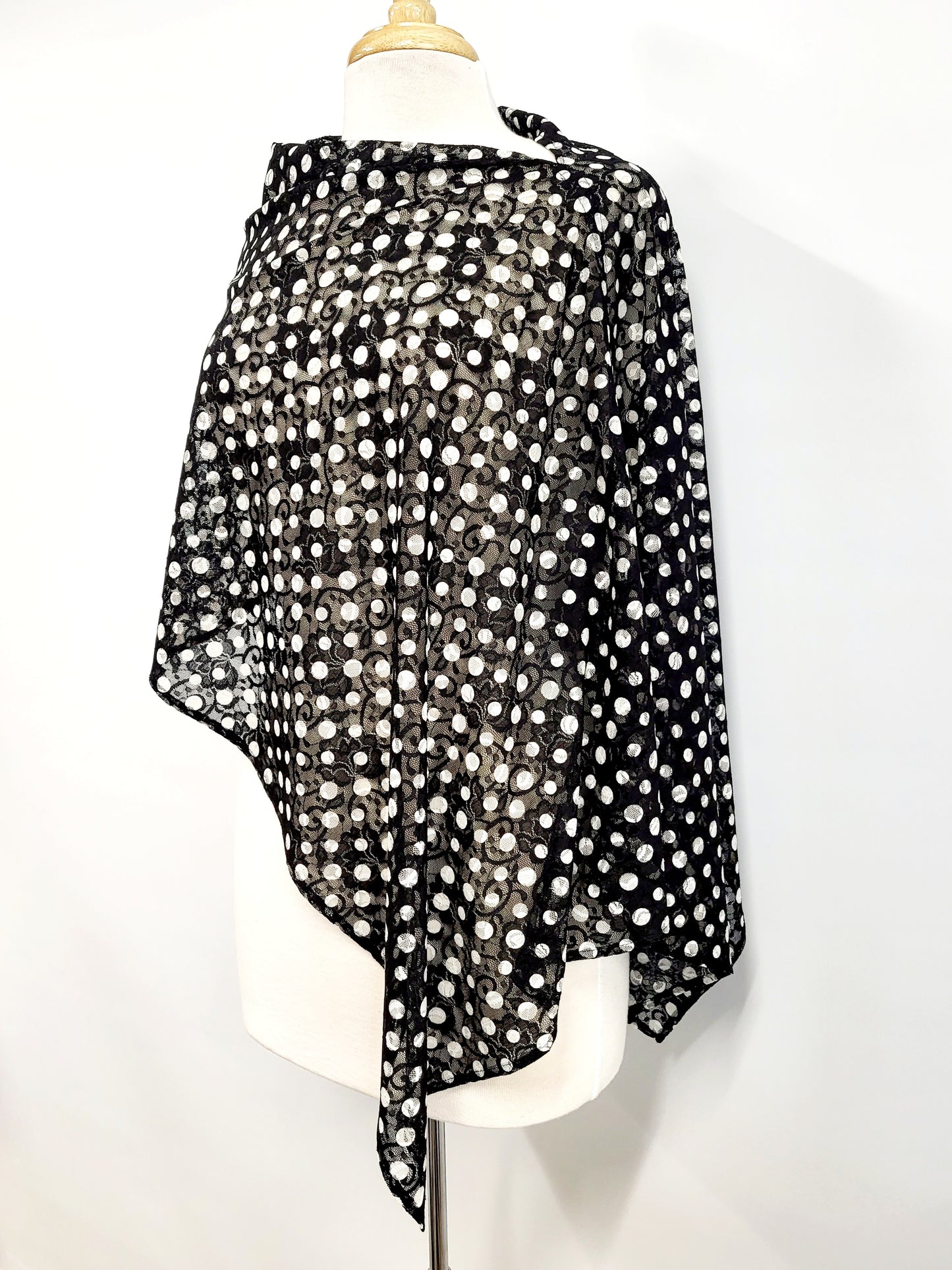Short poncho in black lace with white polka dots.