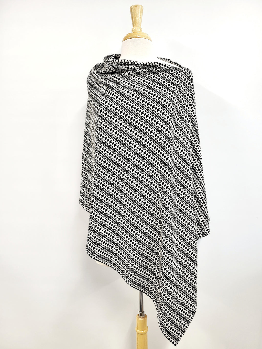Long knitted poncho with white and black pattern.