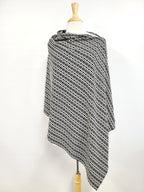 Poncho long en tricot à motif blanc et noir.