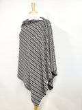 Long knitted poncho with white and black pattern.