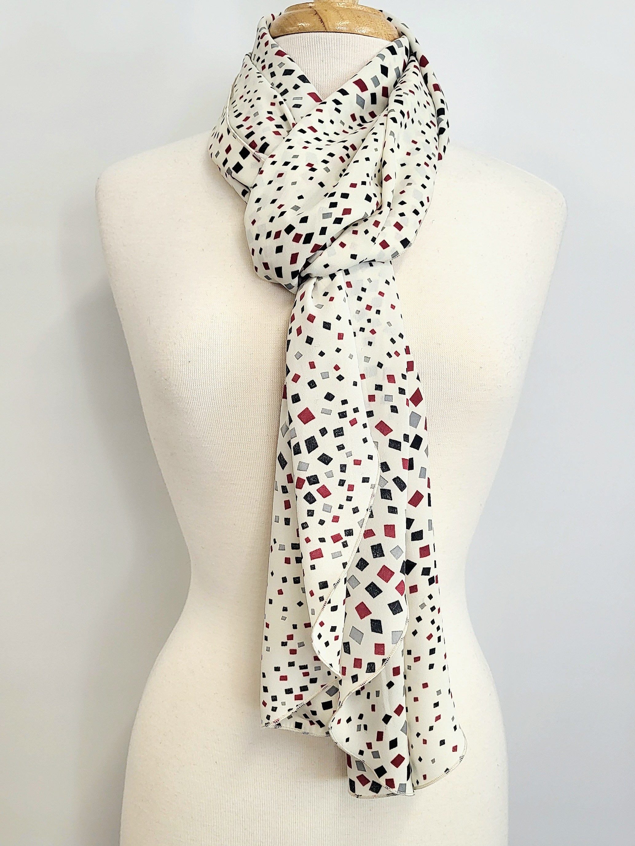 Foulard long imprimé de petits carrés noir, gris et bourgogne sur fond écru.