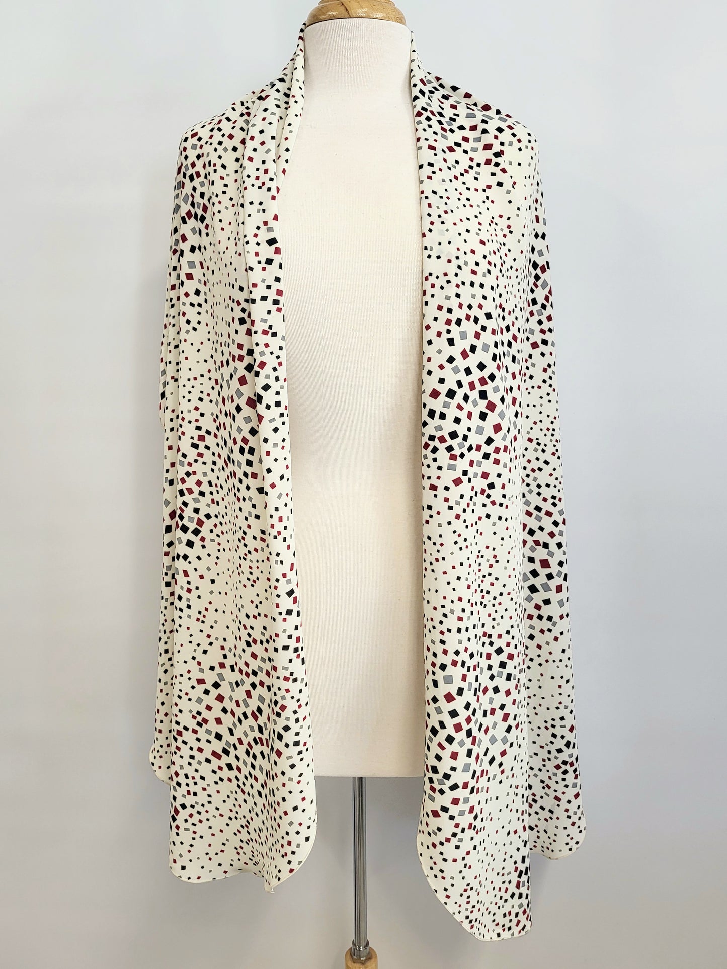 Foulard long imprimé de petits carrés noir, gris et bourgogne sur fond écru.