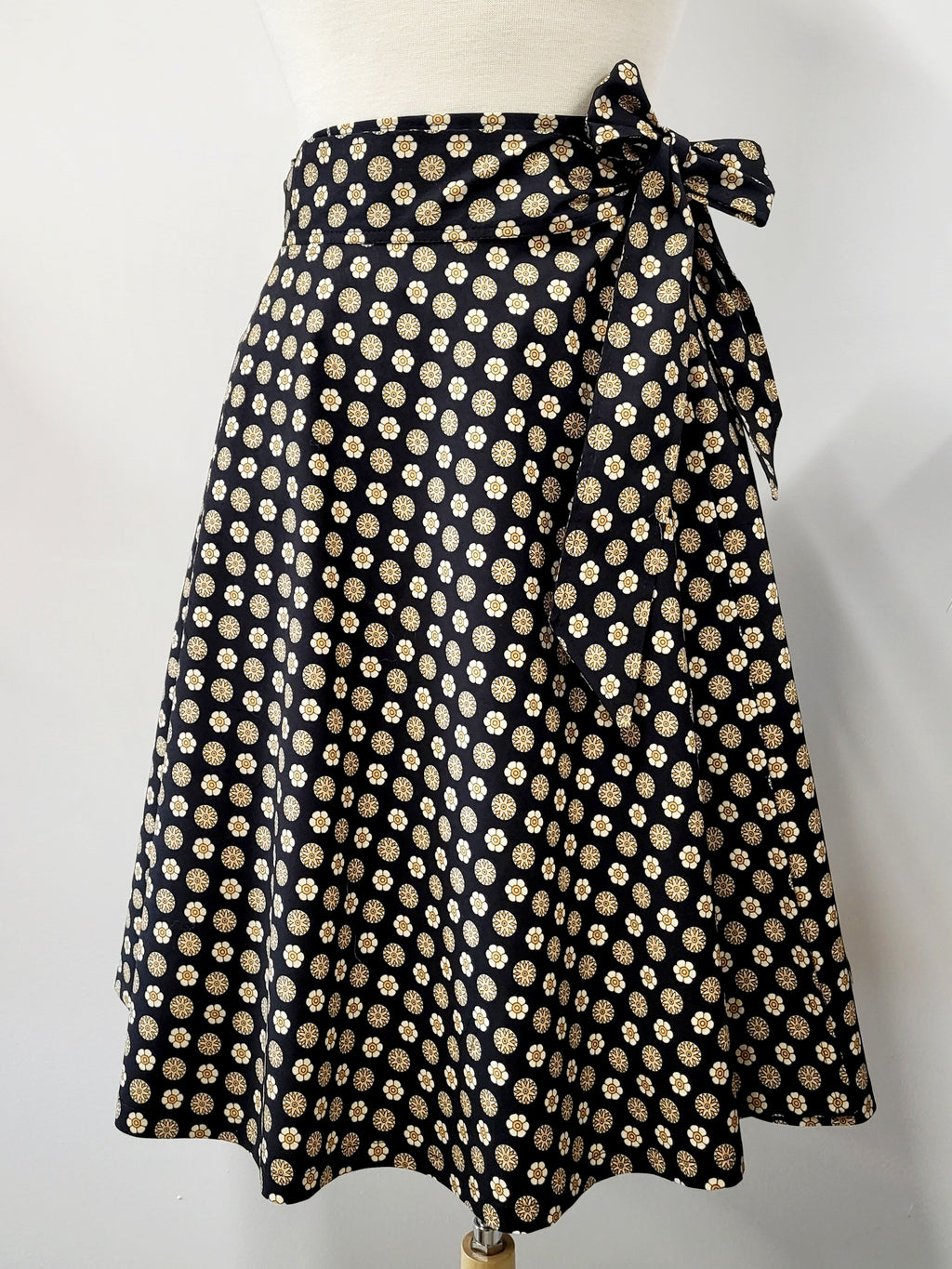 Cotton wrap skirt with small beige and yellow patterns on a black background