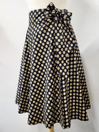 Jupe portefeuille en coton à petits motifs beige et jaune sur fond noir