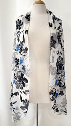 Grand foulard en voilage imprimée de fleurs grises, noires et bleues.