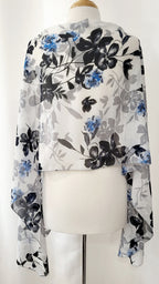 Grand foulard en voilage imprimée de fleurs grises, noires et bleues.