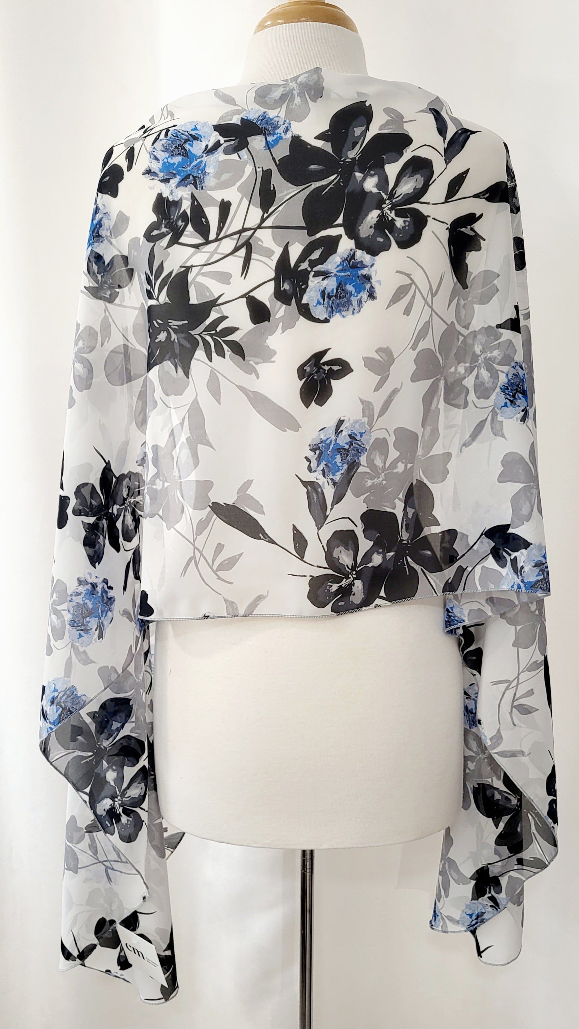 Grand foulard en voilage imprimée de fleurs grises, noires et bleues.