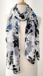 Grand foulard en voilage imprimée de fleurs grises, noires et bleues.