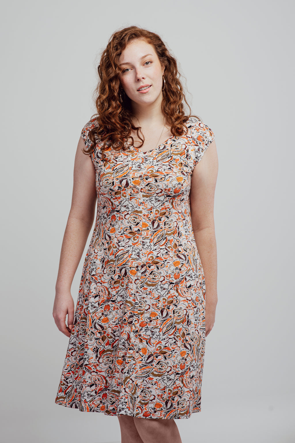 Alice dress with warm-toned print on a white background