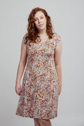 Alice dress with warm-toned print on a white background