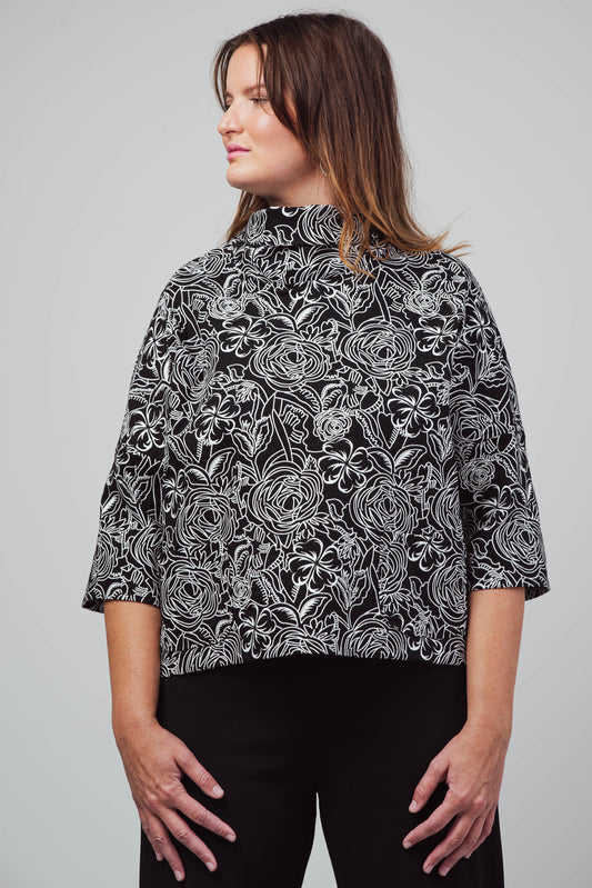 Haut Julie - ample à col haut et poches en tricot noir et blanc, motif floral.