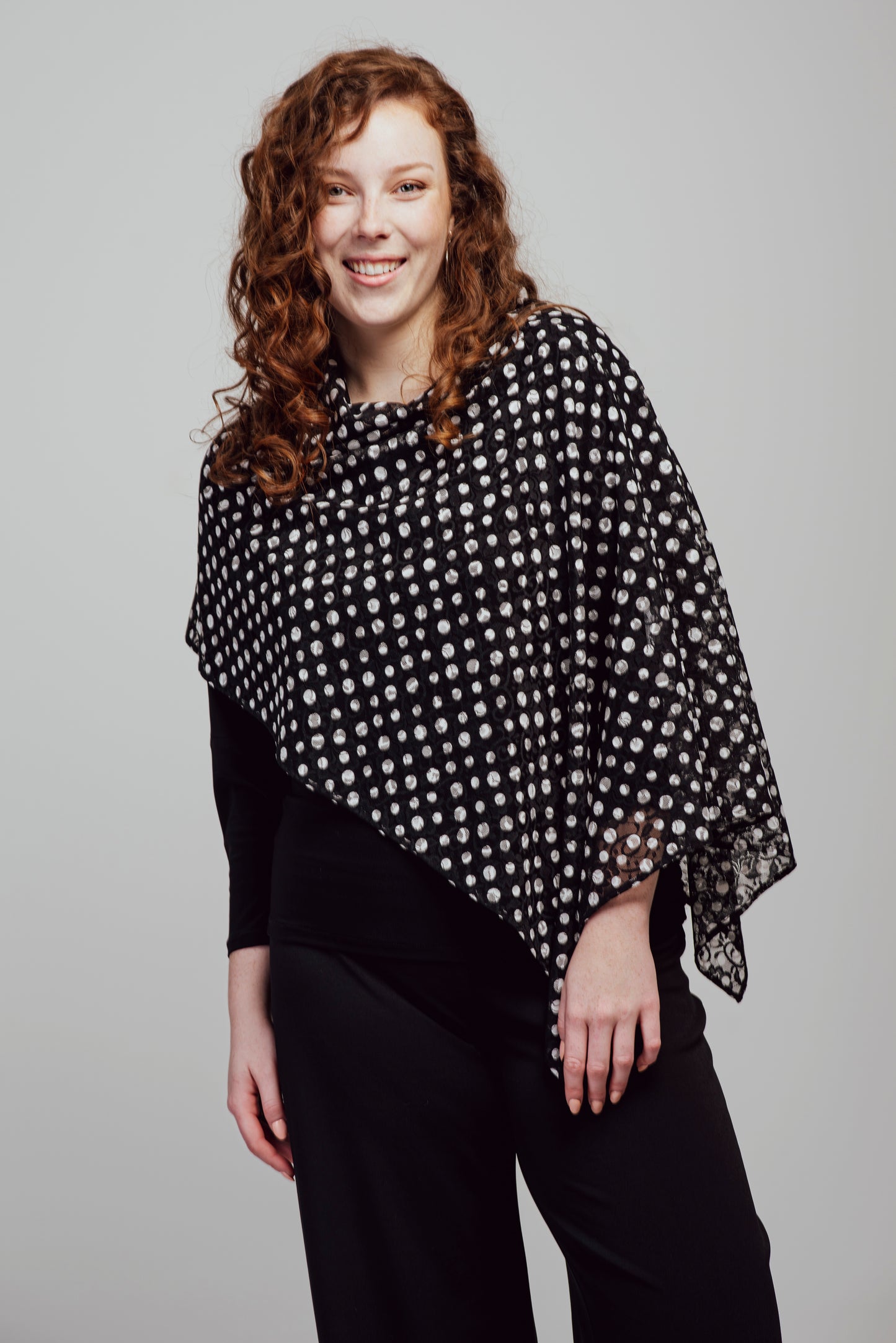 Short poncho in black lace with white polka dots.