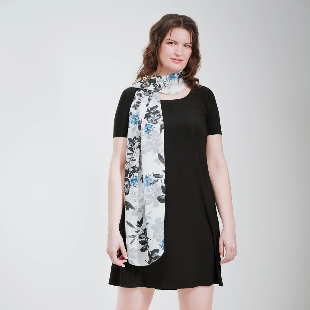 Grand foulard en voilage imprimée de fleurs grises, noires et bleues.