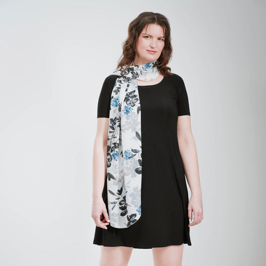 Grand foulard en voilage imprimée de fleurs grises, noires et bleues.