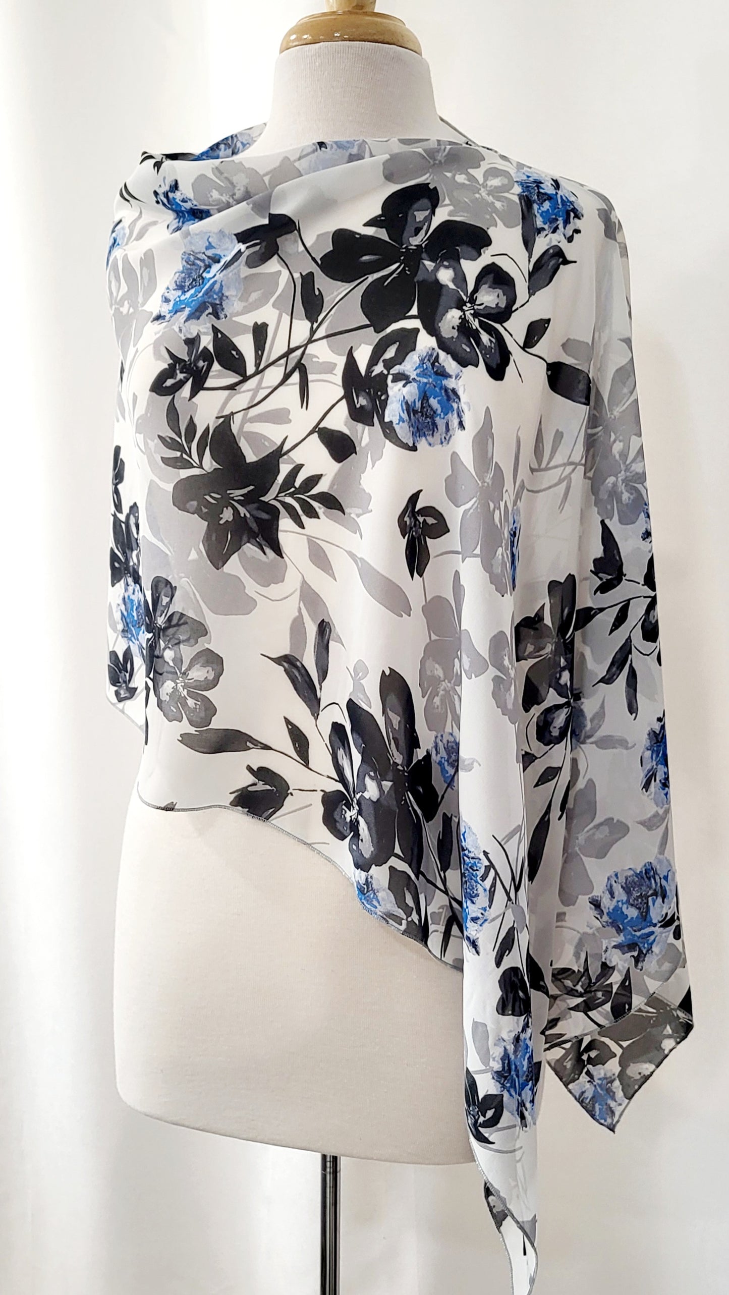 Poncho court en voilage fleuri noir, gris et bleu sur fond blanc
