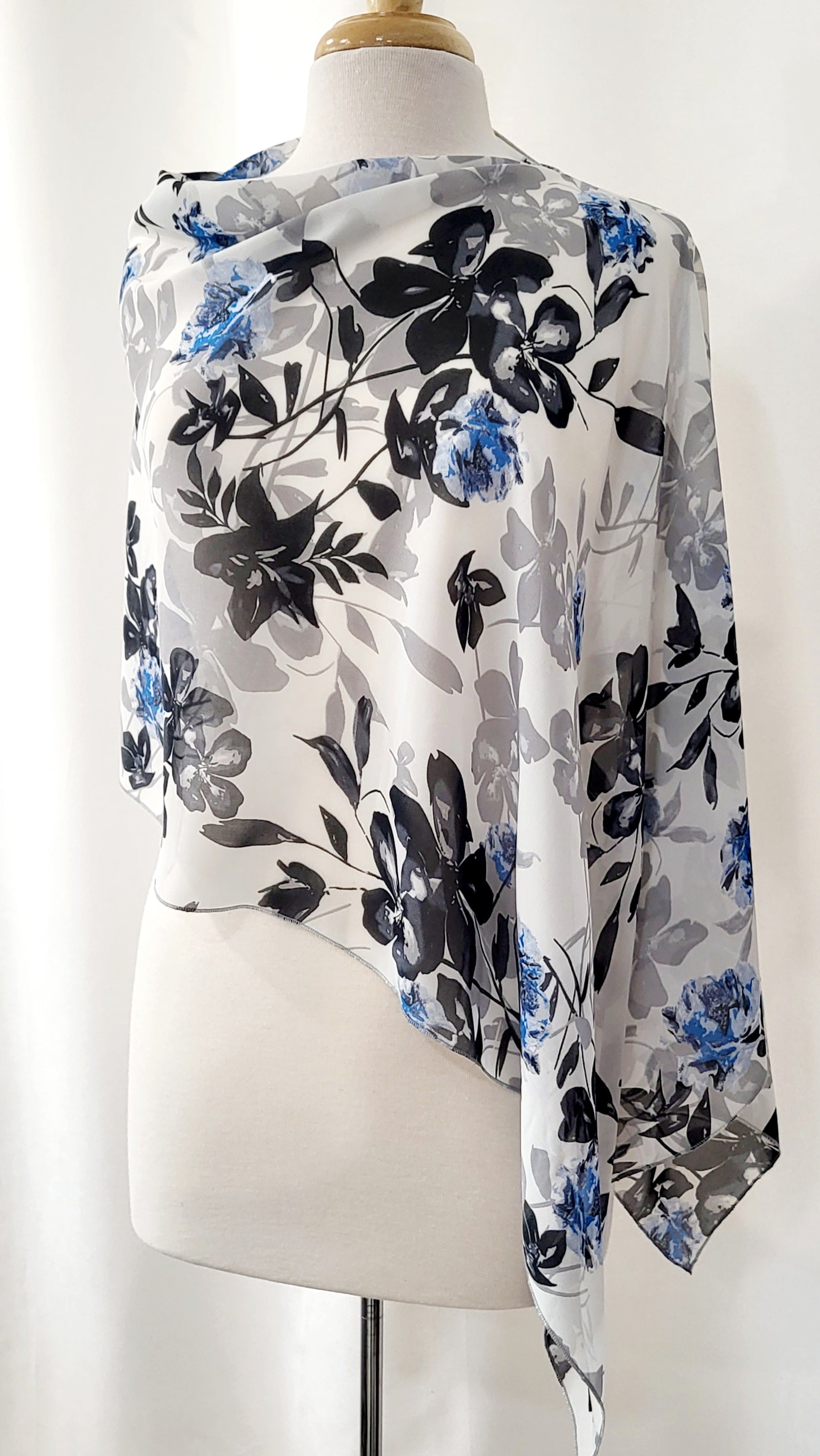 Poncho court en voilage fleuri noir, gris et bleu sur fond blanc