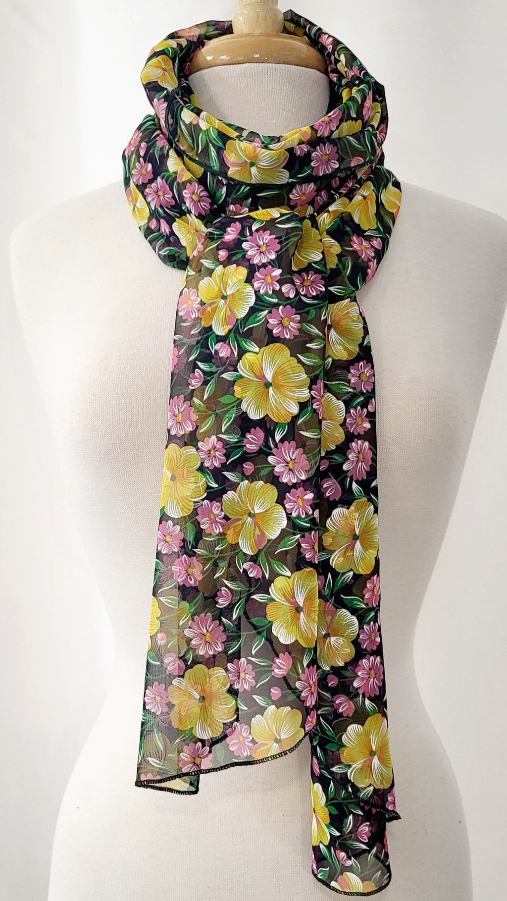 Foulard long en voilage imprimé de fleurs jaunes, roses et feuillage vert.