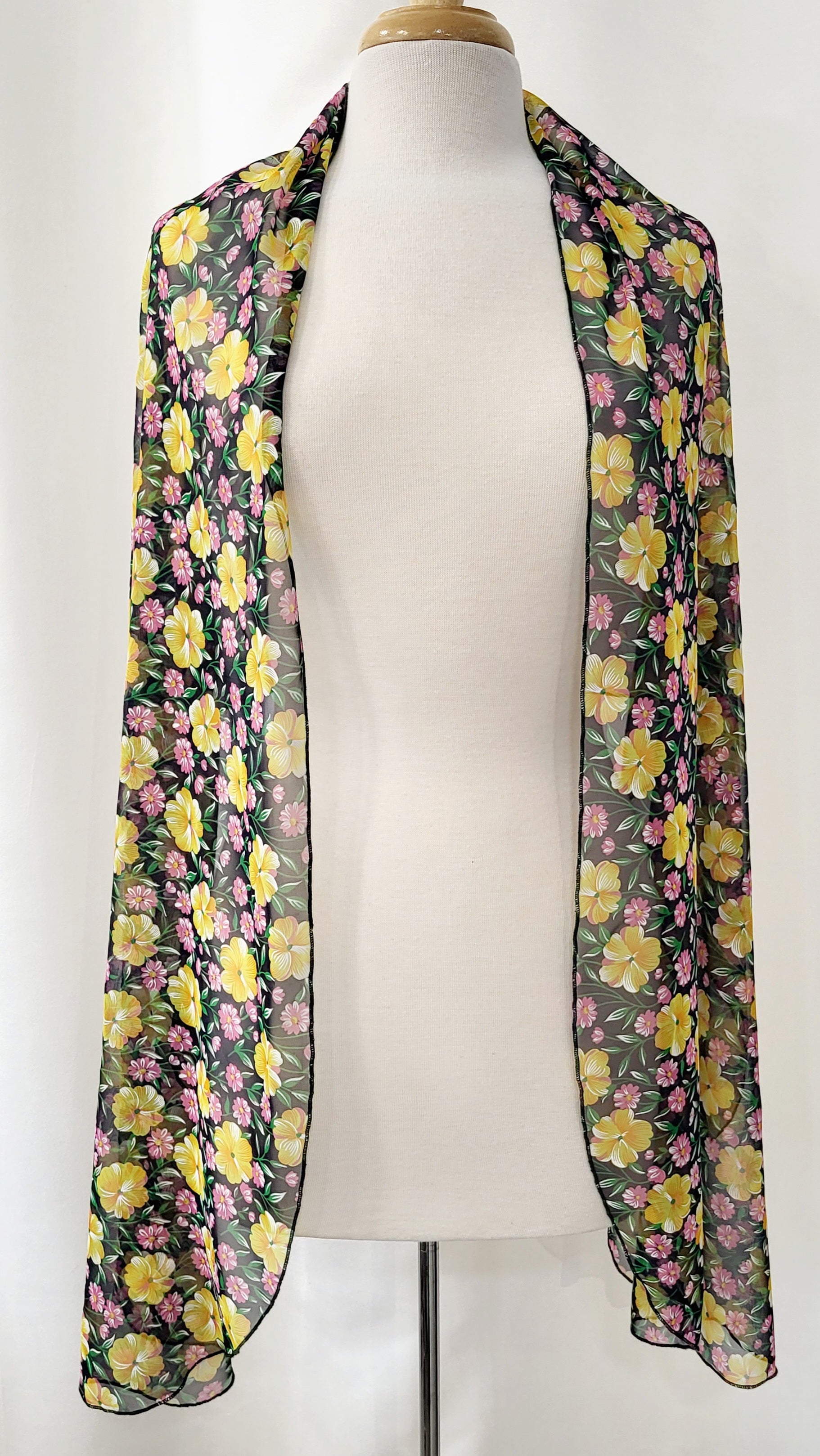 Foulard long en voilage imprimé de fleurs jaunes, roses et feuillage vert.