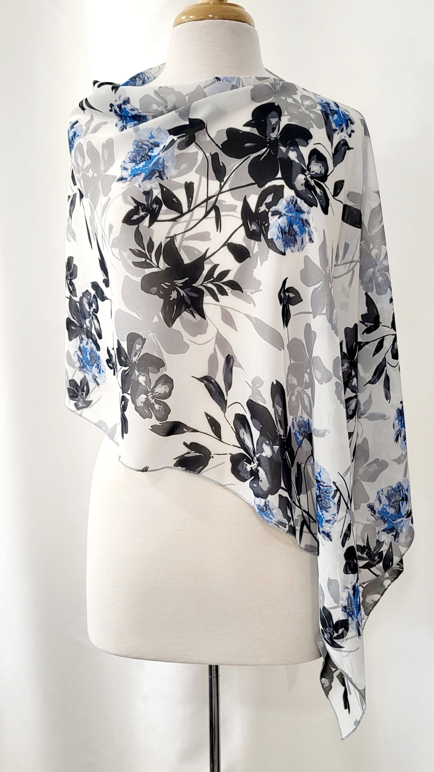 Poncho court en voilage fleuri noir, gris et bleu sur fond blanc