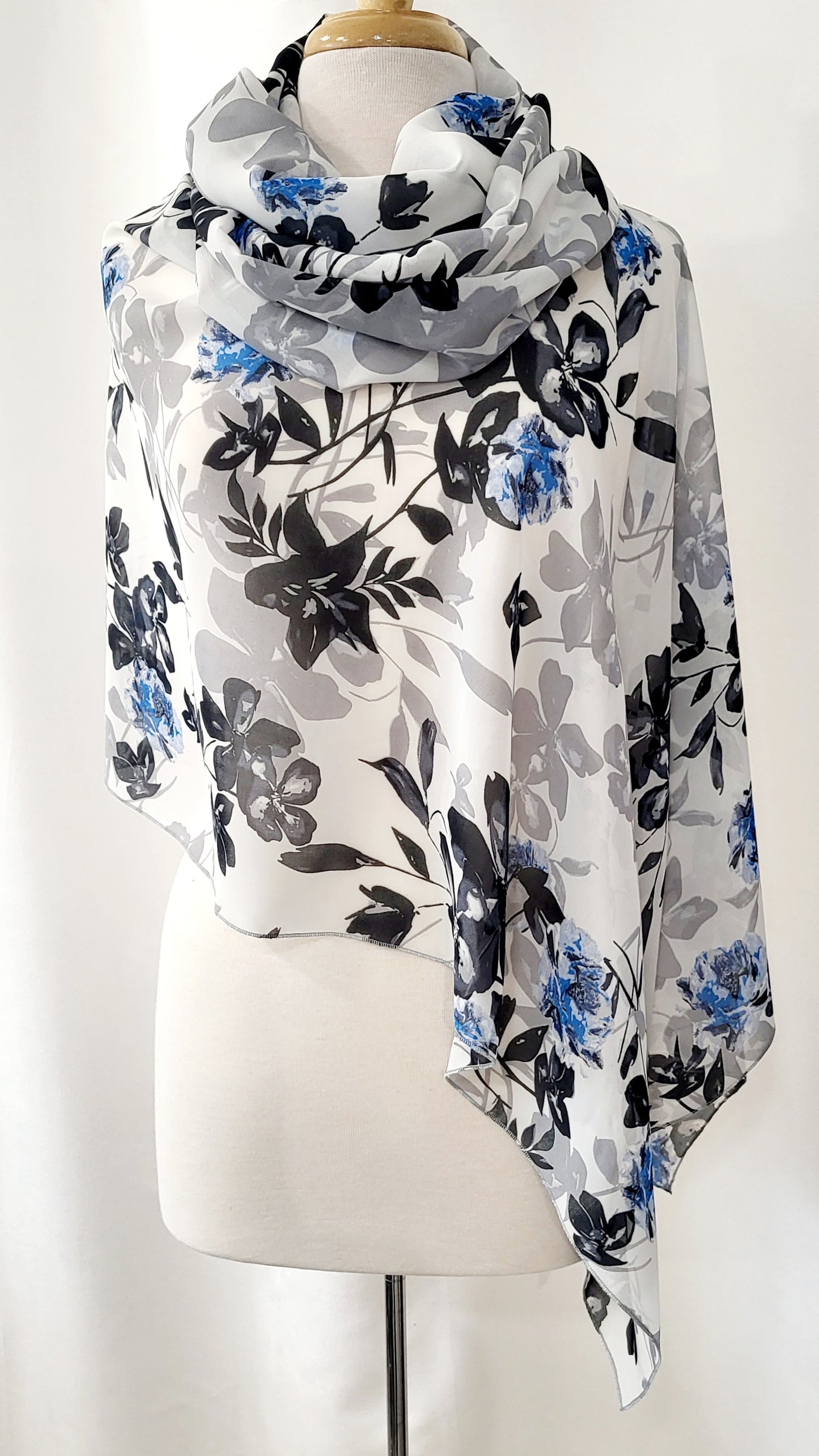 Poncho court en voilage fleuri noir, gris et bleu sur fond blanc
