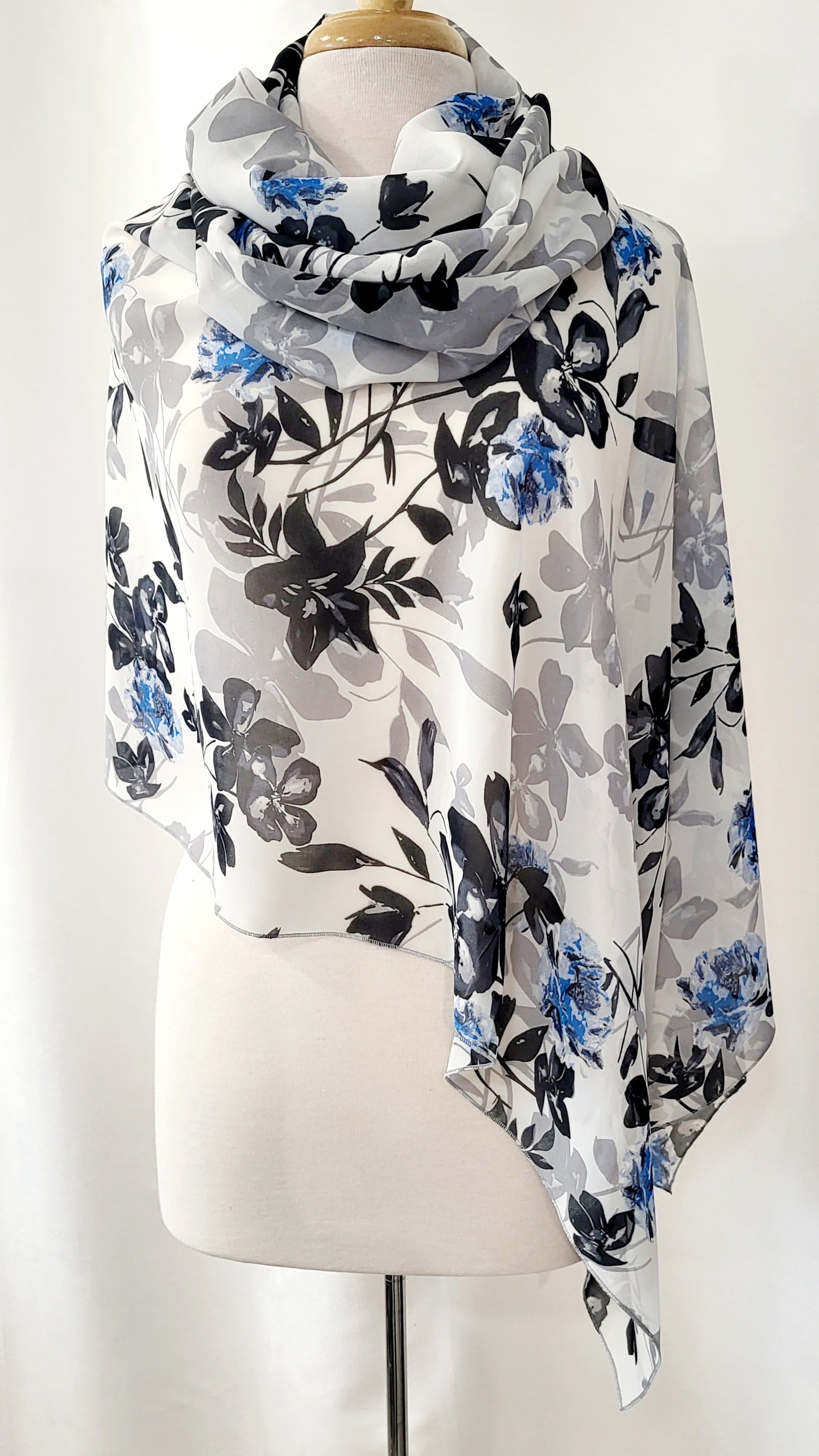 Poncho court en voilage fleuri noir, gris et bleu sur fond blanc