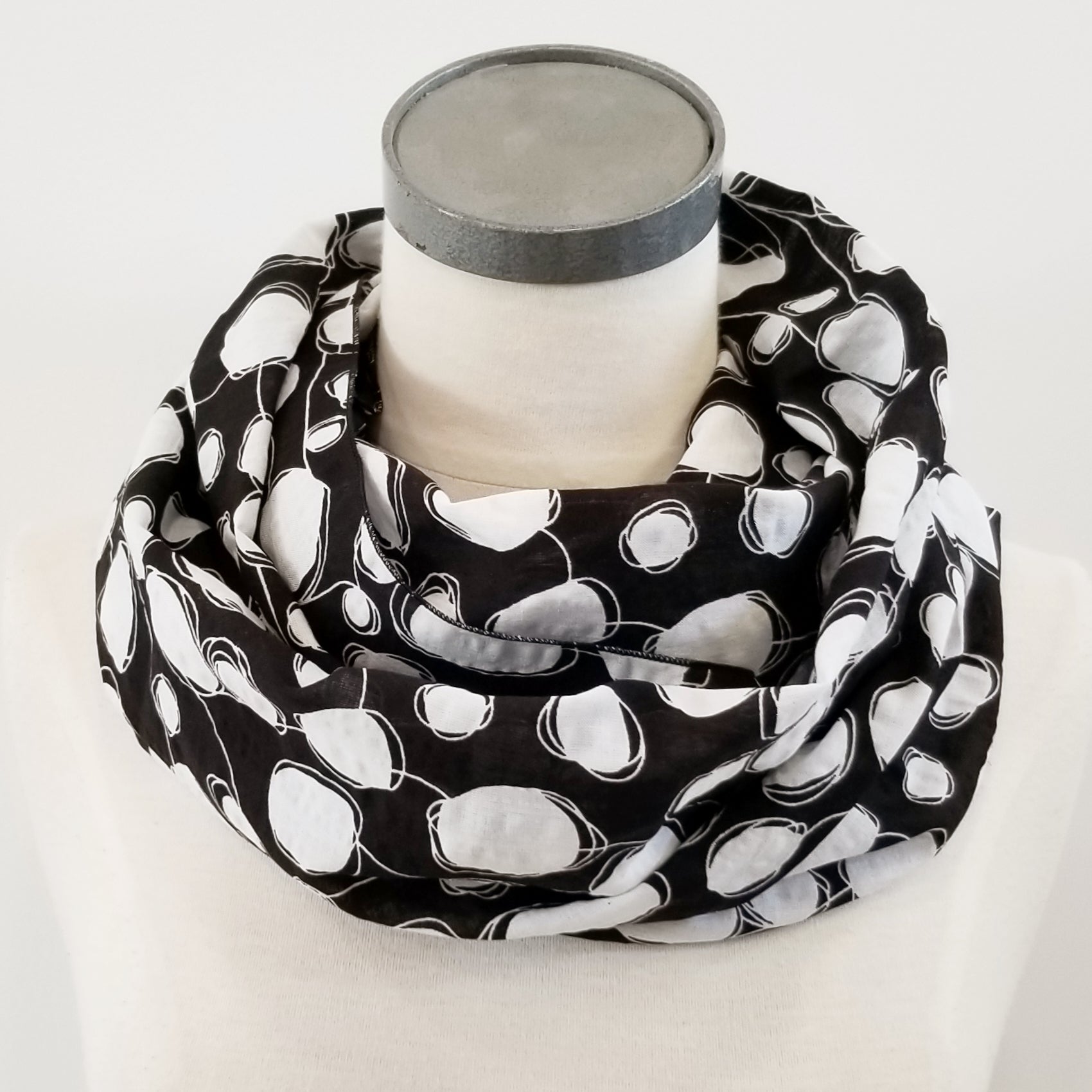 Foulard circulaire imprimé blanc sur noir.