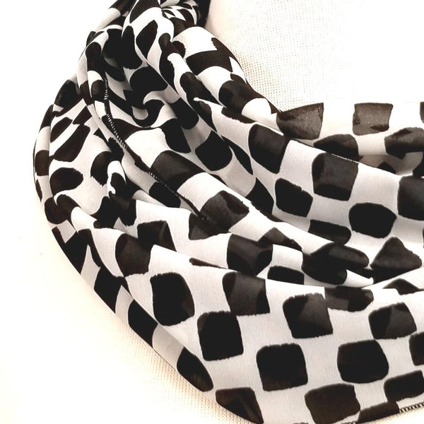 Foulard circulaire à motif damier noir et blanc.