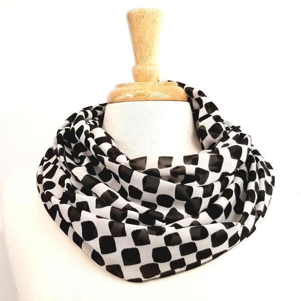 Foulard circulaire à motif damier noir et blanc.