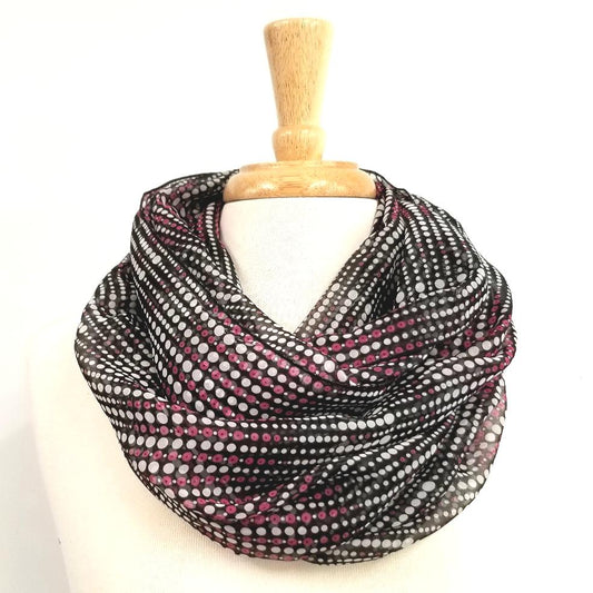 Circular scarf with small purple and white polka dots on a black background.