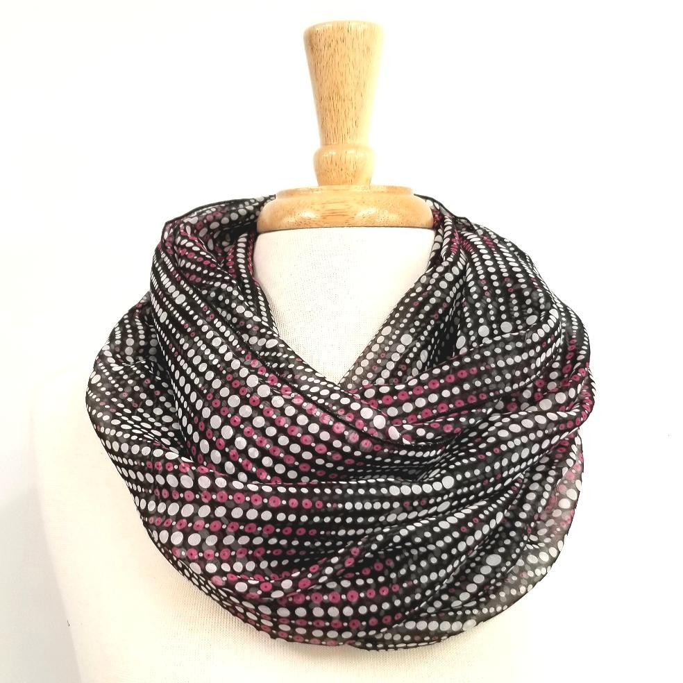 Foulard circulaire à petits pois mauve et blanc sur fond noir.