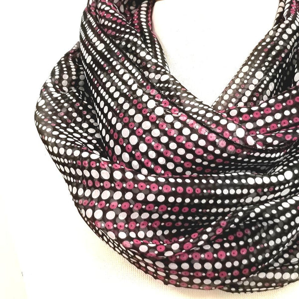 Foulard circulaire à petits pois mauve et blanc sur fond noir.