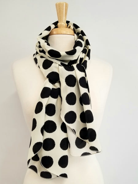 Foulard long en soie, imprimé pois noirs sur fond écru.