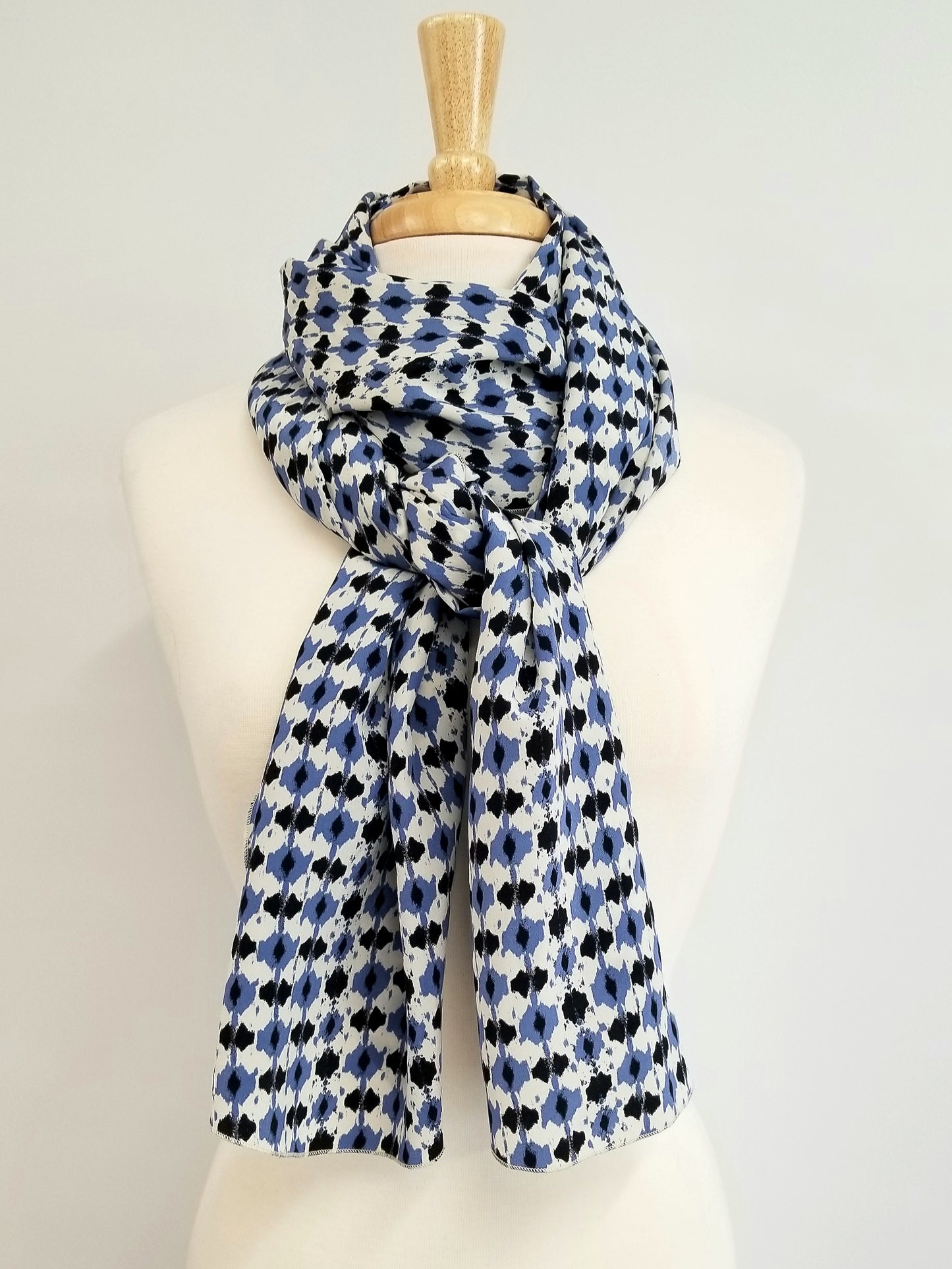 Foulard long en soie, imprimé bleu, noir et blanc cassé.