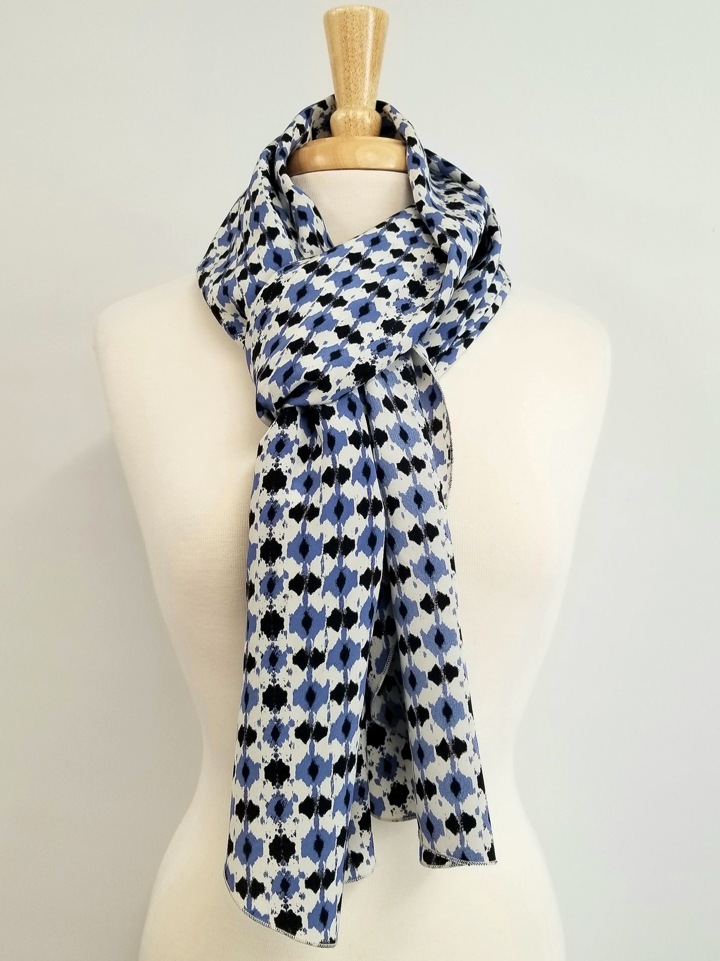 Foulard long en soie, imprimé bleu, noir et blanc cassé.