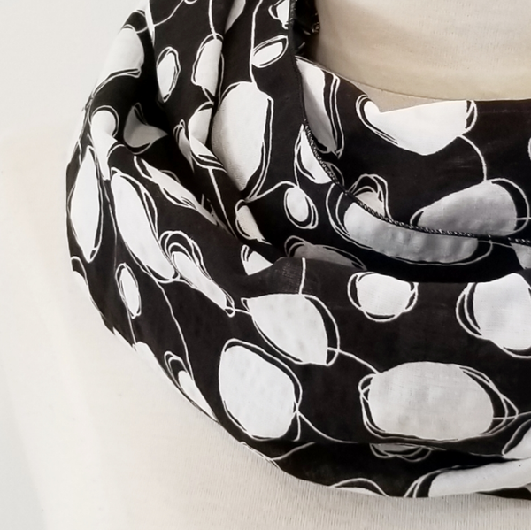 Foulard circulaire imprimé blanc sur noir.